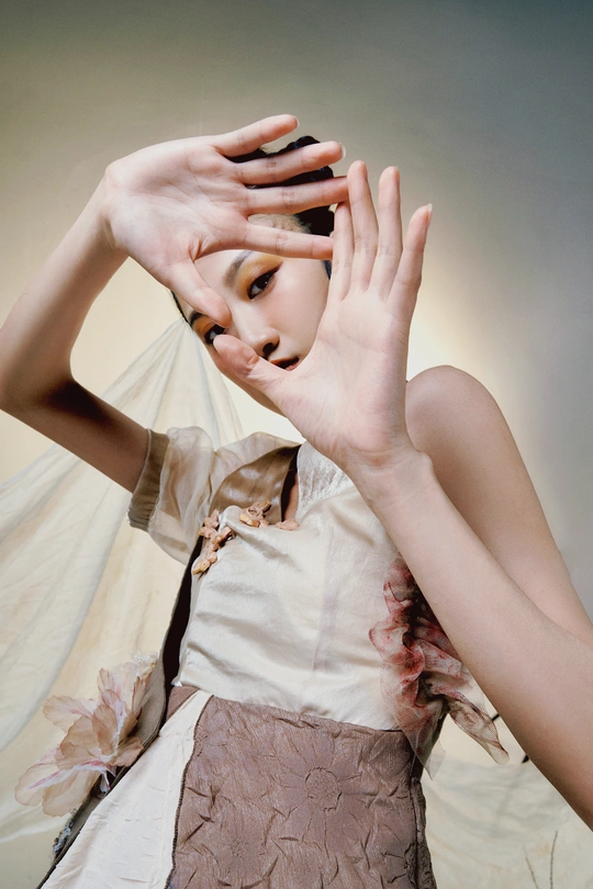 一个穿着白色连衣裙的女人把手举到脸上