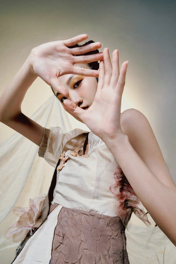 一个穿着白色连衣裙的女人把手举到脸上