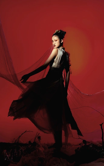 一个穿着黑色连衣裙的女人站在红底上