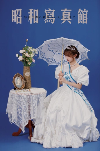 一个穿着白色连衣裙、打着蓝色雨伞的年轻女子