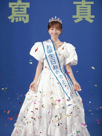 一位穿着传统连衣裙的年轻女子正在佩戴五彩纸屑