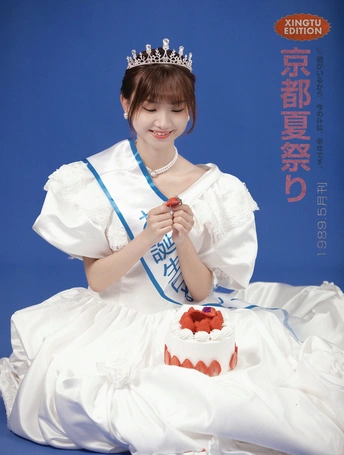 一位身穿白色服装、头戴王冠的年轻女子坐在蛋糕旁