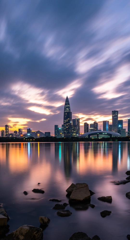 夜晚城市的长时间曝光照片 前景中有天际线和水。