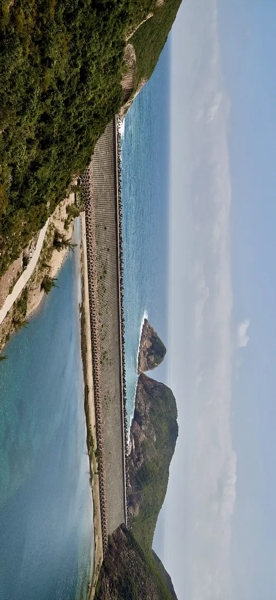 岛屿海岸线的沙滩、悬崖和一片水域的空中视角