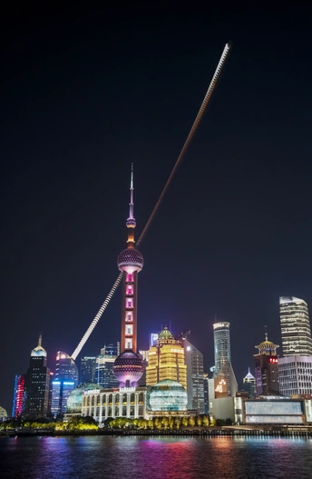 夜晚一座城市天际线被一座高塔点亮 塔在水面上飞翔。