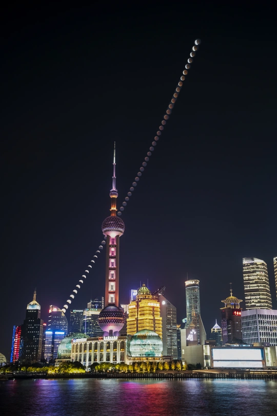 夜晚的城市 天际线高耸的建筑物 水上飞行的亮着灯的飞机。