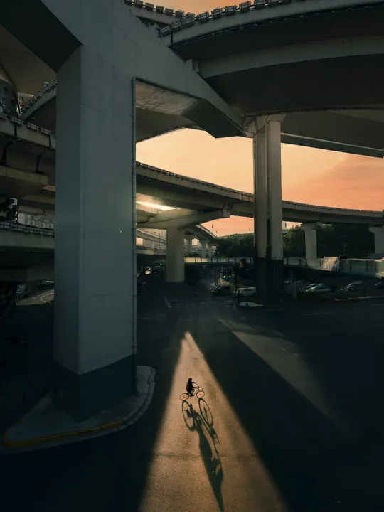 夕阳下 一个人骑自行车在桥下