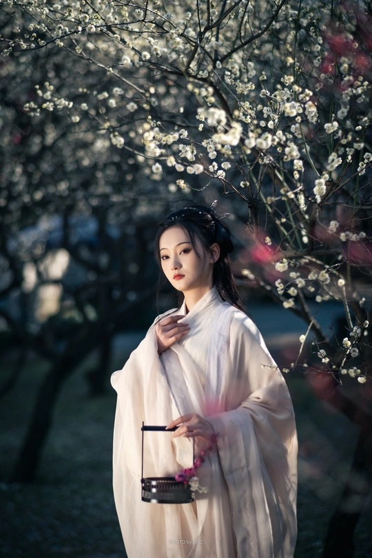 一位穿着传统白色和服的年轻女子抱着一个年轻女孩