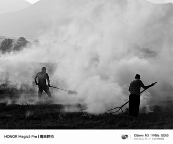 黑白照片 背景是烟雾弥漫的田地 有男性工作者。