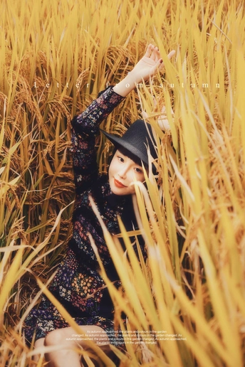 一个穿黑色衣服的女孩坐在一片高草地上