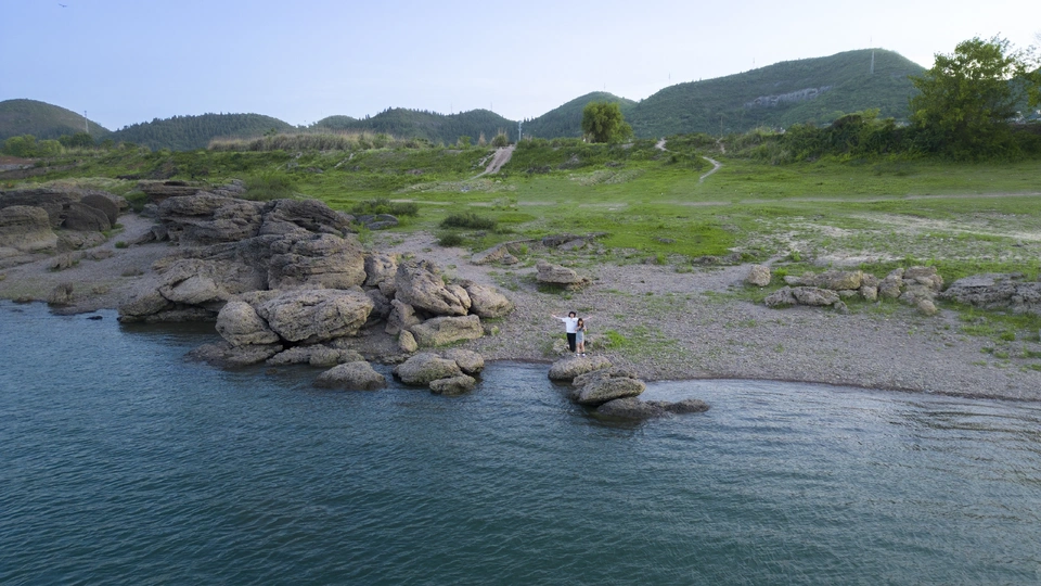 河或湖中的岩石上站着一个人