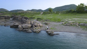 河或湖中的岩石上站着一个人