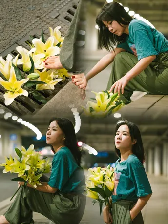 一位女子递给小女孩一束黄色的百合花。
