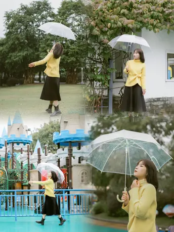 一个年轻女孩举着雨伞在游乐场 一个妇女在雨中站着