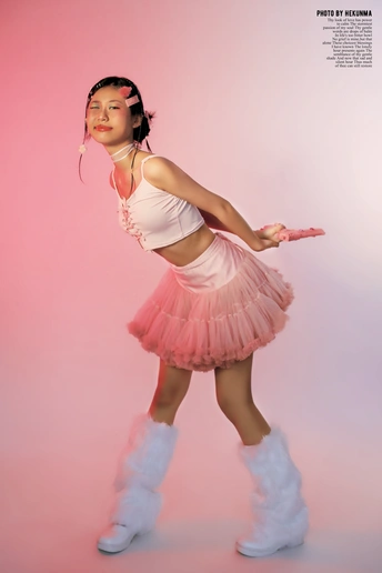 一个穿着粉色连衣裙和白色靴子的年轻女子正在跳舞