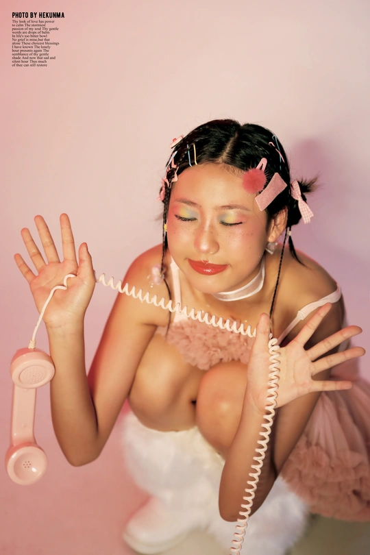 一个穿着粉红色连衣裙的年轻女子手里拿着一部粉红色的电话