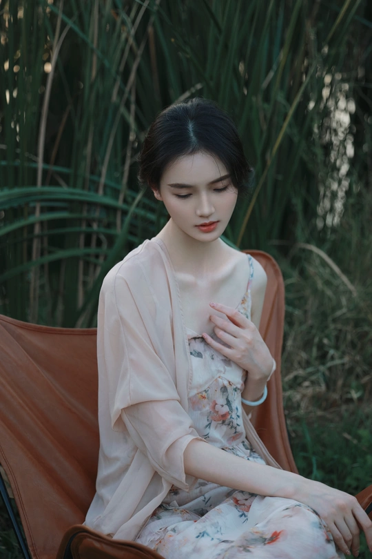 一个穿着连衣裙坐在吊床上的年轻女子