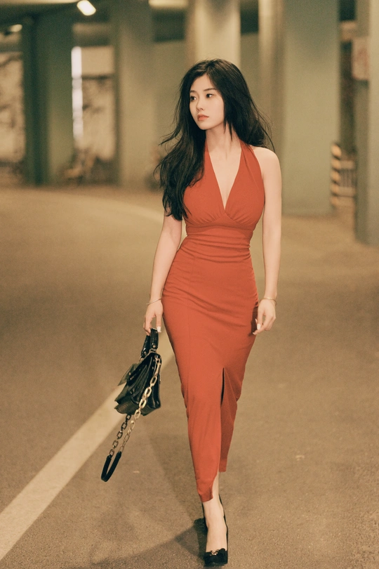 一位穿着橙色裙子的女人正在行走