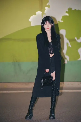 一位穿着黑色外套和黑色靴子的女士