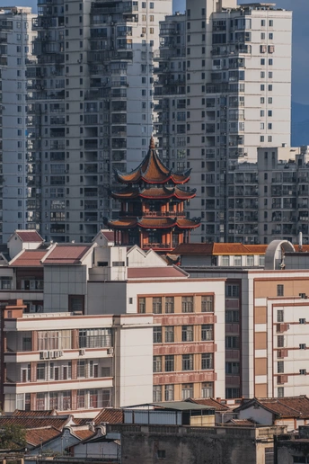 在城市的一座高楼前面有一座佛塔。