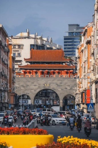 一条街道 有汽车、摩托车、人和建筑物。