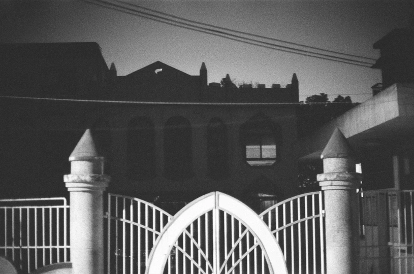 一张黑白照片 照片中有一扇位于房子前面的门。