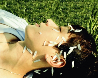 一对年轻男女躺在草地上 脸对着对方的眼睛
