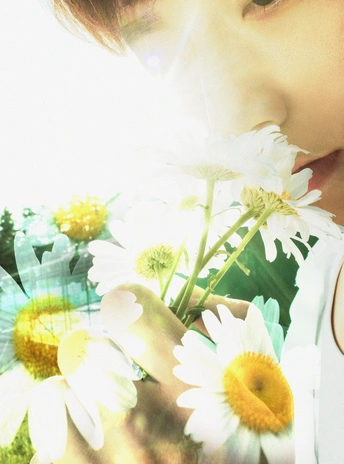 一个年轻女孩手里拿着一朵白花 一个男孩在上面吹