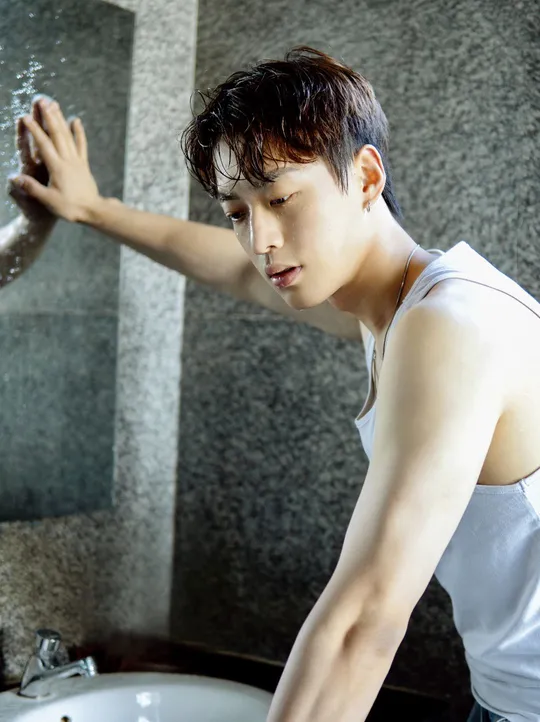 一个年轻男子在浴室里洗头 一个女子用水洗她的手和脸。