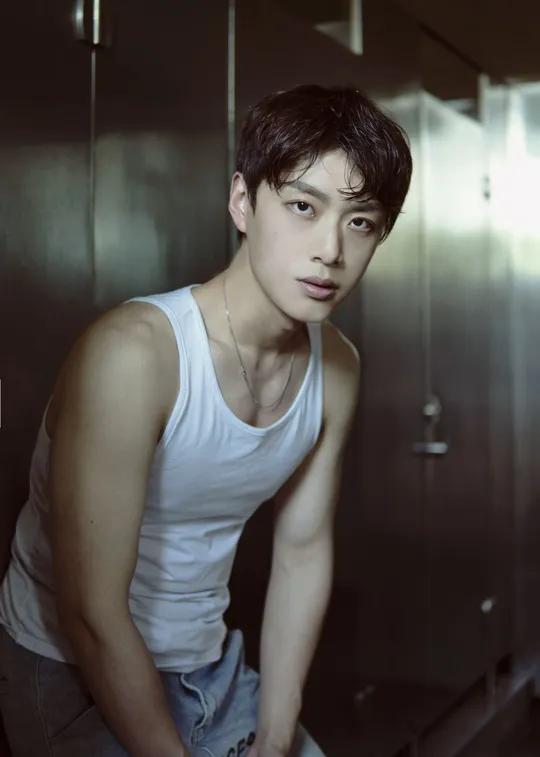 一个穿着白色背心的年轻人正在为肖像拍照。