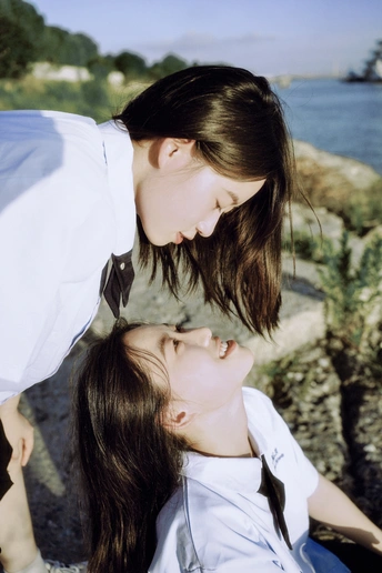 一位年轻女子和一位小女孩在靠近水的海滩上
