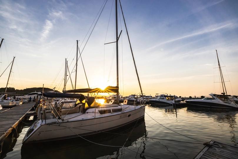 夕阳西下时 几艘帆船停泊在港口的码头上。