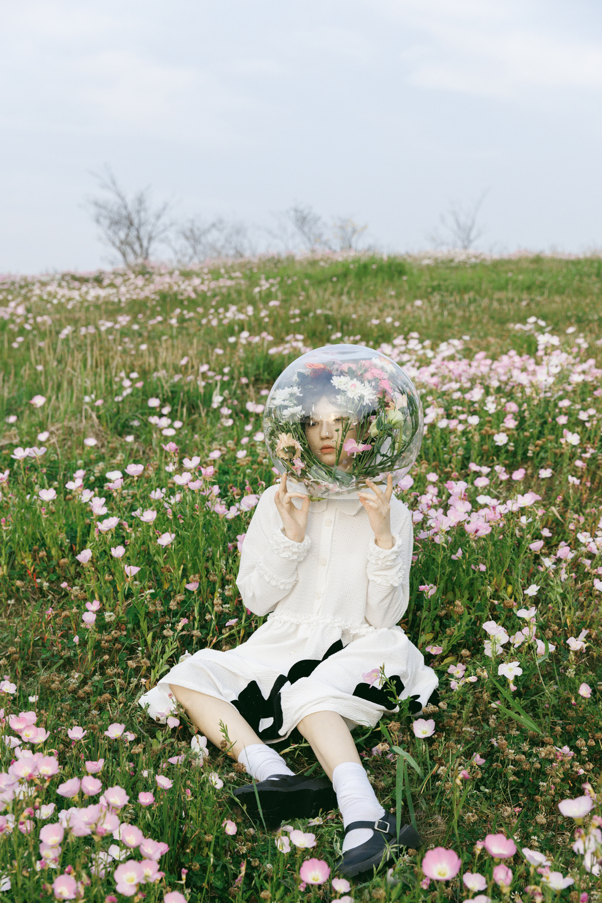 一位年轻女子坐在花丛中 用手托着脸庞
