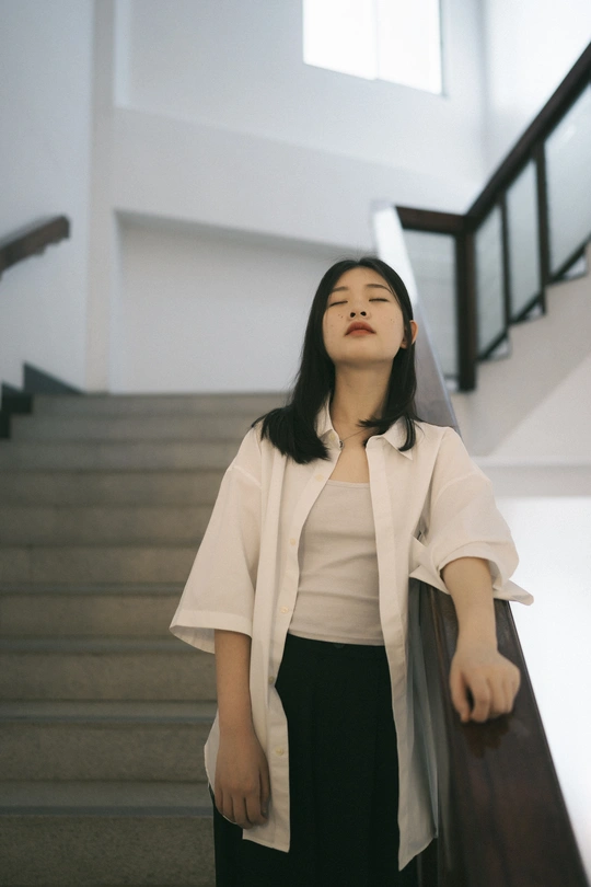 一位年轻女子站在一些楼梯前