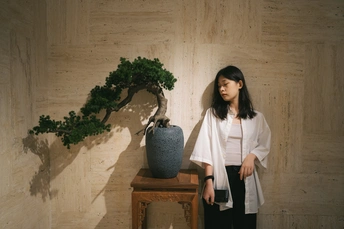 站在一个有花瓶的桌子旁的年轻女子