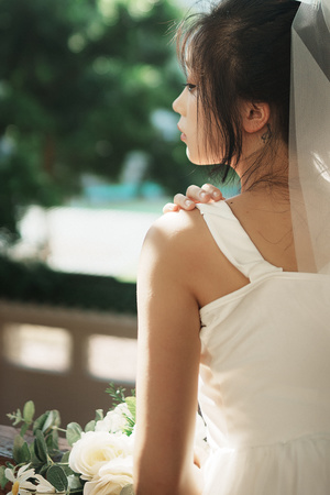 一位戴白色长裙和面纱的女人正在凝视窗外