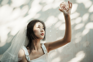 一位穿着白色婚纱和头纱的年轻女子举手