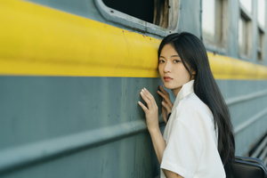 一位年轻女子正在火车窗口向外伸头