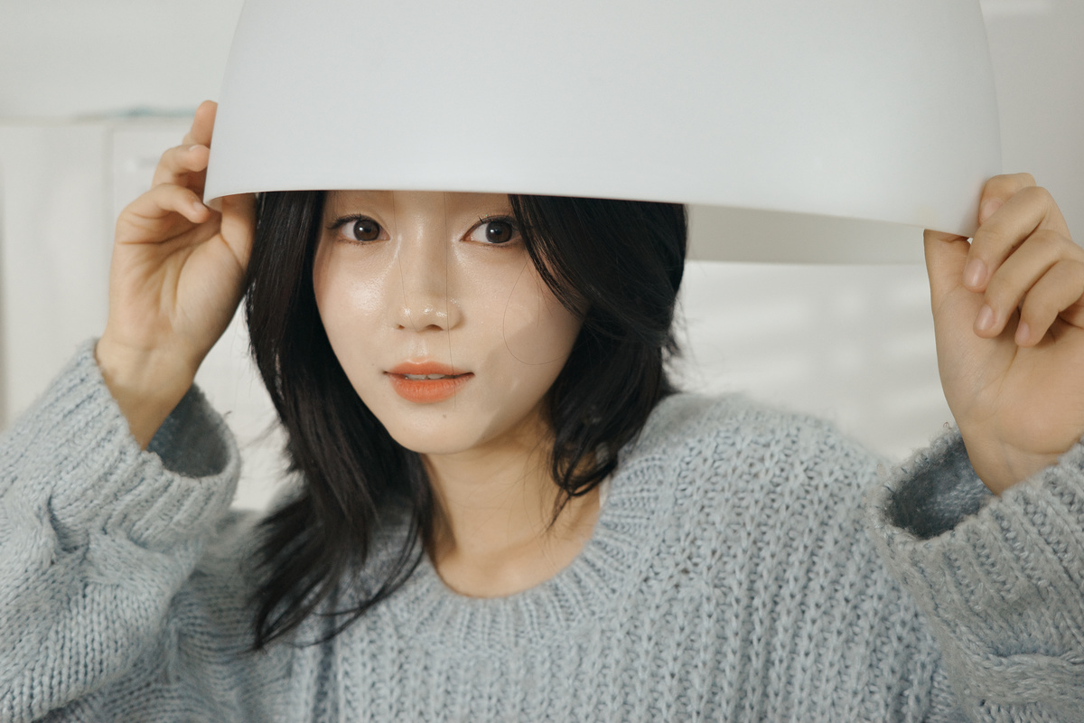 一个戴白色帽子 用纸片遮住脸的年轻女子