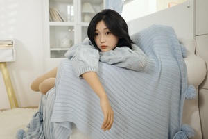 一个年轻女子躺在蓝色的毛毯下