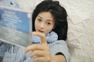 一个年轻女子抱着一本书躺在床上