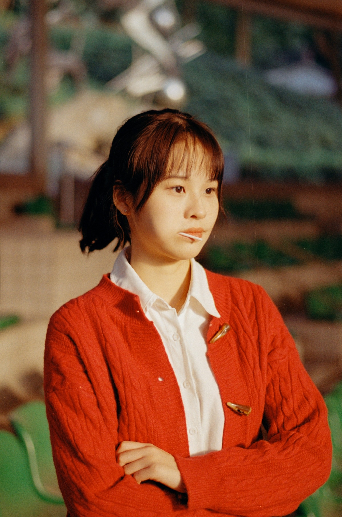 一位穿着红色毛衣的年轻女子站在一幅墙纸上。