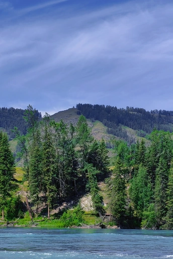 背景有河流、山丘、树木和山脉。