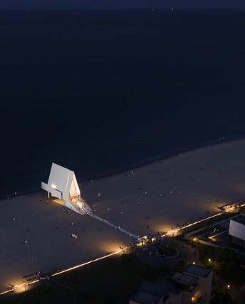 一座白色建筑在夜晚亮起灯光 俯瞰大海