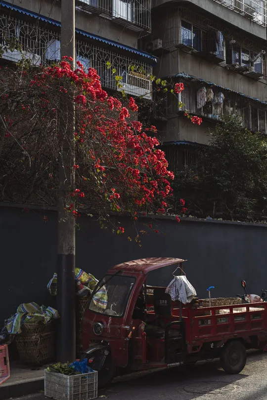 一辆红色的消防车停在公寓楼前的路边 一名男子路过。