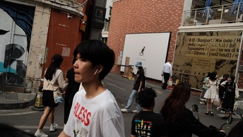 一个年轻人站在街上与一大群人交谈。