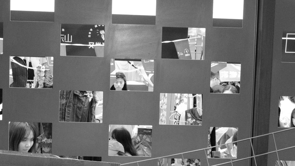 一张黑白照片 女孩正在墙壁上的镜子里看自己的倒影。