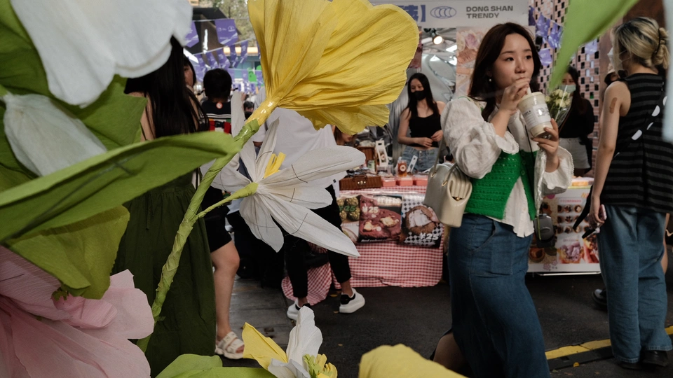 人们在市场周围拿着伞和花