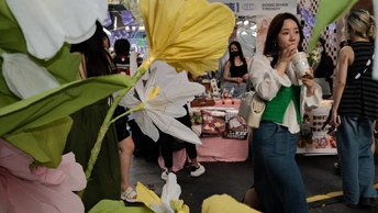 人们在市场周围拿着伞和花