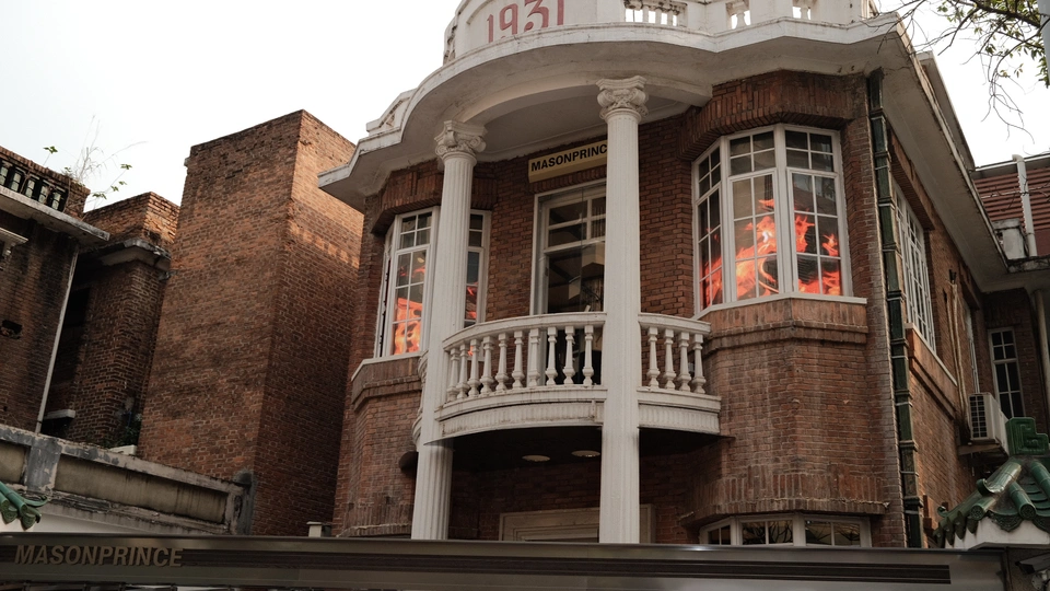 一座高大的红砖建筑 顶部有白色塔楼 带有窗户和一个大钟。